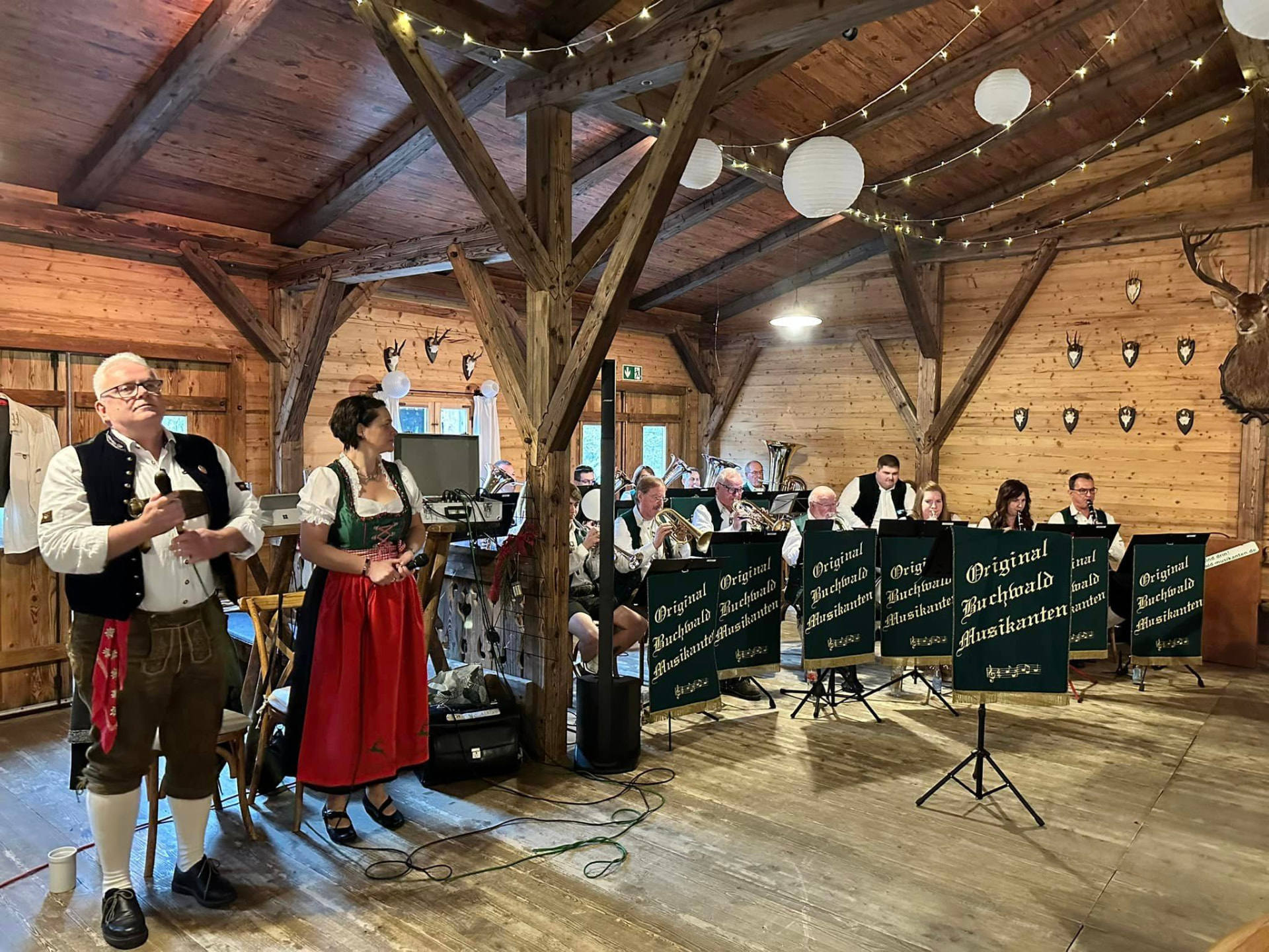 Die Kapelle bei einem Auftritt in einer festlich geschmückten Holzhalle